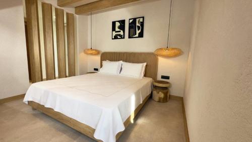贝拉姆卡尔Club Kavala Beach Hotel Assos的卧室配有带两盏灯的白色床