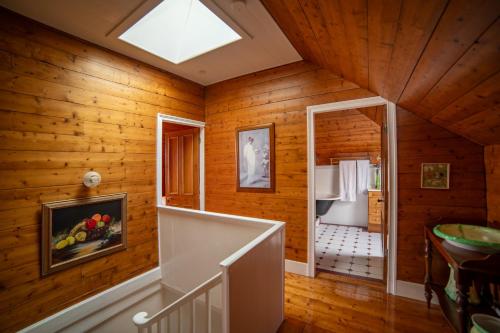 斯坦利Poet's Cottage Stanley的一间设有木墙的客房,房子里设有楼梯