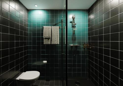 格拉斯哥The Social Hub Glasgow的绿色瓷砖浴室设有卫生间和淋浴。