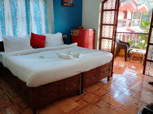 AguadaFLOBESTIAN BEACH VILLA CANDOLIM BEACH的一间卧室配有一张带两条白色毛巾的床