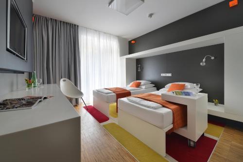 扬斯凯拉兹涅Omnia Hotel Relax & Wellness的酒店客房配有两张床和一张书桌