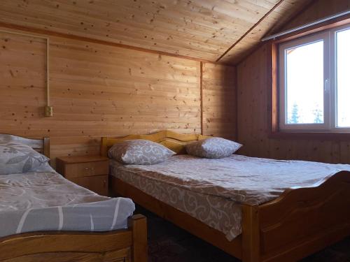 亚布卢尼齐亚Котедж Краєвид的小木屋内一间卧室,配有两张床