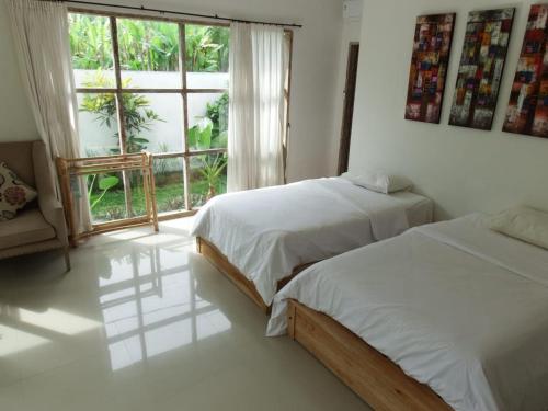 普卢坎Deepblue vila的一间卧室设有两张床和大窗户
