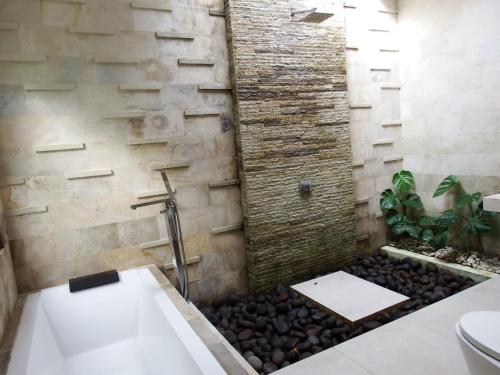 普卢坎Deepblue vila的一间石墙和淋浴的浴室