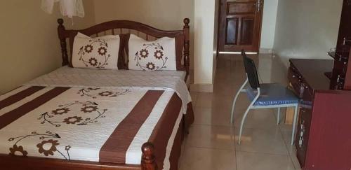 KibogaAtkon Hotel-Kiboga的一间卧室配有一张带桌子和椅子的床