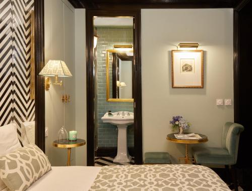 塞维利亚Triana House的一间卧室,配有带水槽的浴室和一张床