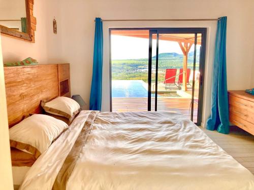 塔马兰Villa Teranga avec vue panoramique sur la baie de Tamarin的一间卧室设有一张床和一个滑动玻璃门