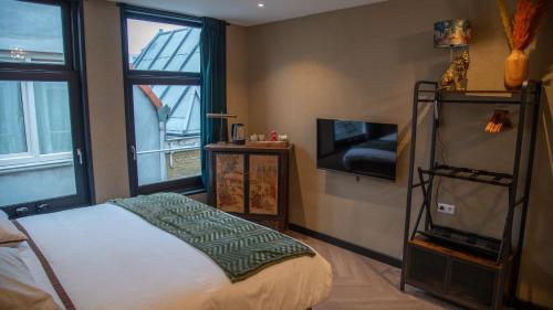 海牙Downtown Suite的一间卧室设有一张床、一台电视和一个窗口。