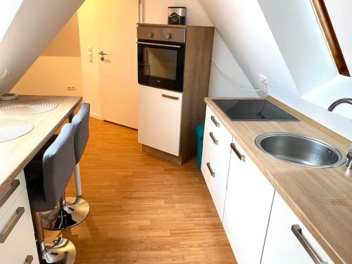 汉诺威gemütliches Apartment Döhren的一间带水槽和微波炉的小厨房