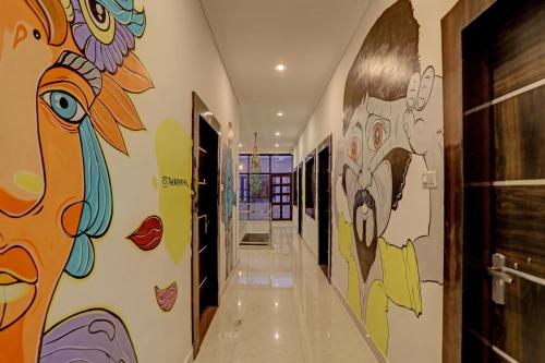 克久拉霍Super OYO Madpackers Khajuraho的墙上挂有绘画的走廊