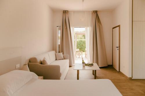 奥特朗托塞拉德利阿里米尼3号牵牛星公寓式酒店的白色卧室配有沙发和桌子