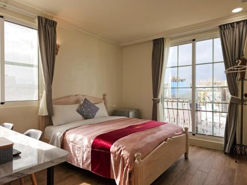 垦丁大街垦丁寻梦园的一间卧室设有一张床和一个大窗户