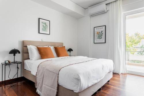雅典Capacious 3BR apartment in the heart of Marousi的白色卧室配有带橙色枕头的大床
