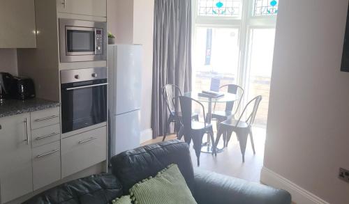 哈罗盖特Harrogate Lifestyle Luxury Serviced ApartHotel的带沙发的客厅和带桌子的厨房