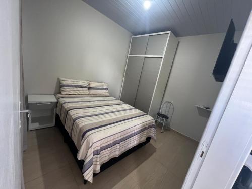 伊瓜苏Boicy Residence的小卧室配有带条纹毯子的床