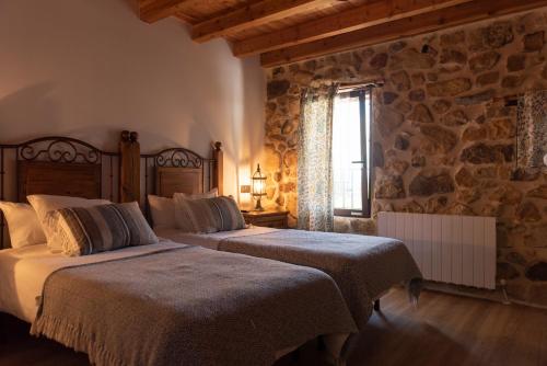 San MarcosArialdegi的一间卧室设有两张床和石墙