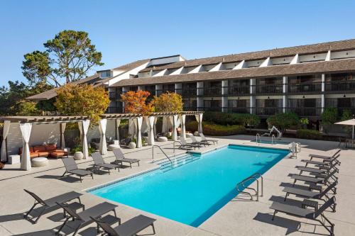 蒙特雷蒙特雷希尔顿花园旅馆的一座带游泳池和椅子的酒店和一座建筑