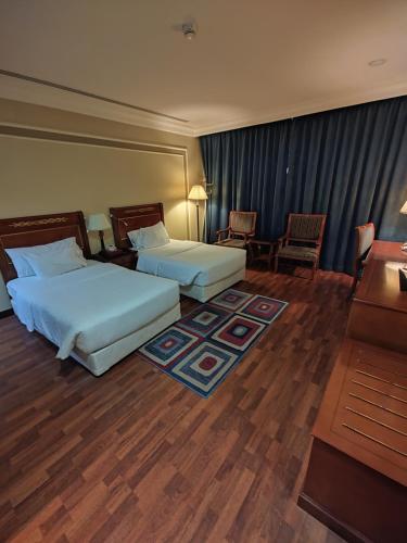 阿可贺巴فندق كارم الخبر - Karim Hotel Khobar的酒店客房配有两张床和一张书桌
