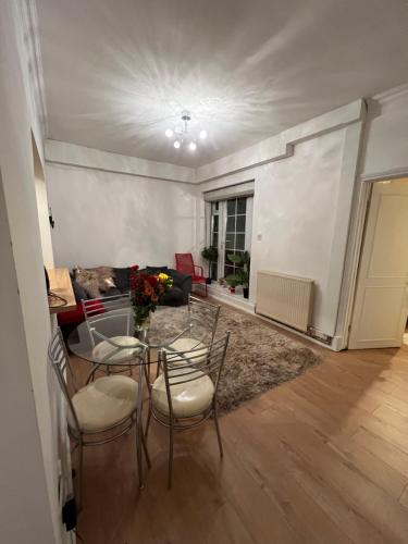 伦敦Double bedroom in chelsea的客厅配有桌椅和沙发