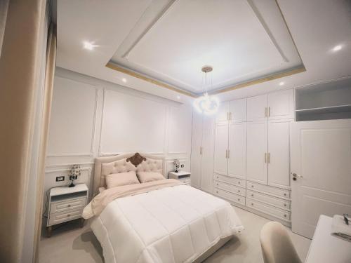 地拉那Villa Pasha Tirane的白色卧室配有一张大床和白色橱柜