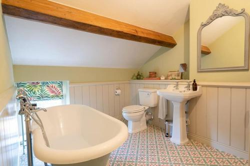 巴斯洛Charming Coates Cottage的一间带水槽、浴缸和卫生间的浴室