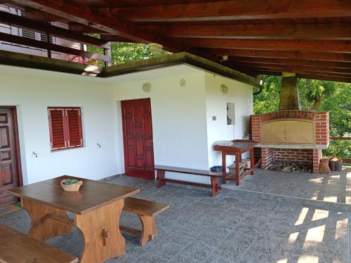 Stubicke TopliceTessina kuća的户外庭院设有壁炉和木桌。