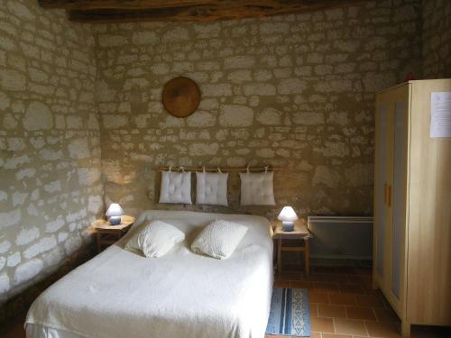 Ambillou-Château窑洞旅馆的一间卧室配有一张床和浴缸