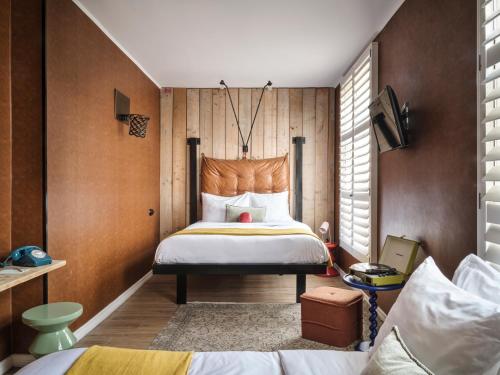 阿姆斯特丹Max Brown Hotel Museum Square, part of Sircle Collection的一间卧室设有一张大床和木墙