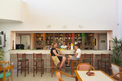 普罗塔拉斯Pola Costa Beach Hotel Apts - Adults Only的一群坐在酒吧里的人