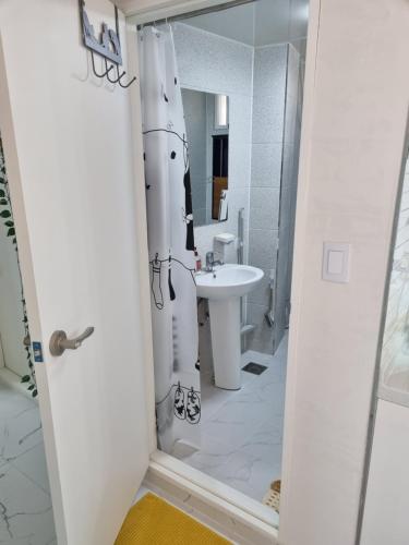 江陵市Sinami的白色的浴室设有水槽和淋浴帘