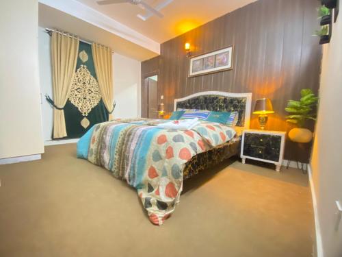 伊斯兰堡Viceroy Royal Hotel Apartment Islamabad的一间卧室配有一张带五颜六色棉被的床