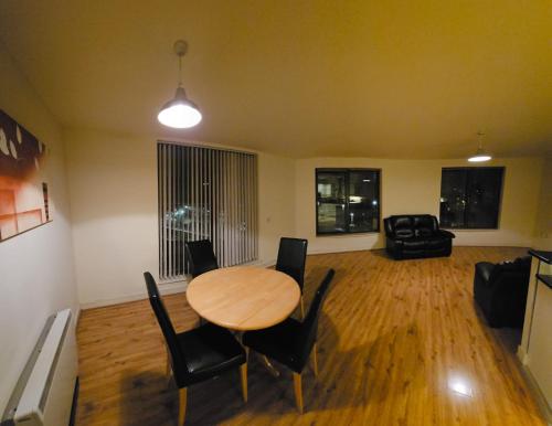 基尔肯尼Penthouse Apartment的客厅配有木桌和椅子