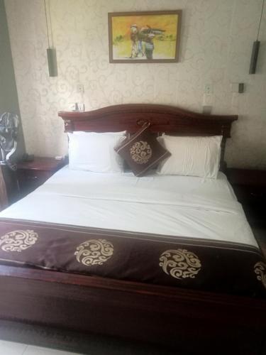 阿库雷CRYSTAL SUITES的一间卧室配有一张大床和木制床头板