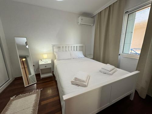 萨罗尼扎Traditional Seaview Maisonette的卧室配有白色床和毛巾