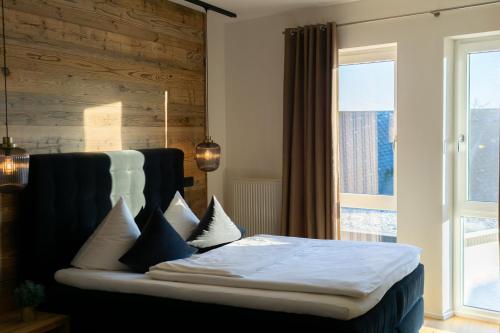 劳森豪森我爱我家酒店的卧室配有带枕头的床铺和窗户。