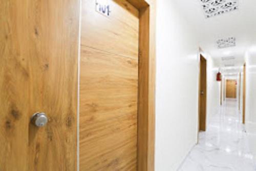 艾哈迈达巴德Hotel Sunrise Inn的一间铺有瓷砖地板的客房内的木门
