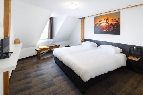 雷讷瑟Hotel Blooker的卧室配有一张白色大床和电视。