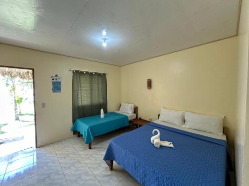 董索Dancalan Beach Resort的客房设有两张带蓝色床单的床和窗户。