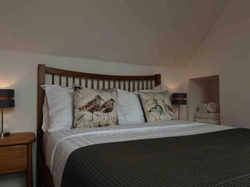 卡博斯特One Bedroom Apartment - Carbost - Skye的一间卧室配有一张带枕头的大床