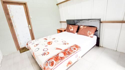 塞姆博伦拉旺Tangga Bungalows的一间卧室配有一张床,床上有蜘蛛床罩