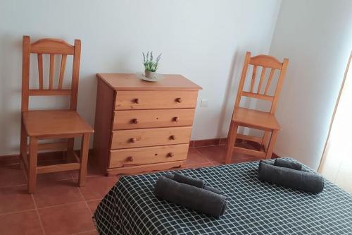 卡耐特蒂贝兰格Acogedor apartamento en la playa de Canet的一间卧室配有两把椅子、一张床和一个梳妆台