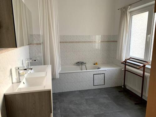 布鲁塞尔Une belle étage à Stockel的白色的浴室设有浴缸和水槽。