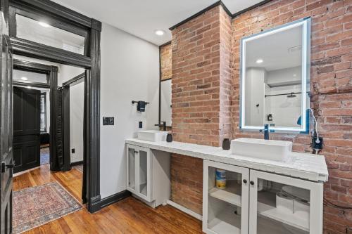 华盛顿Spacious, Historic Logan Circle Rowhouse的一间带两个水槽和砖墙的浴室