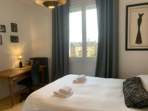 雷恩Le Saint HeL, Magnifique T2 en face du TNB的一间卧室配有一张床、一张书桌和一个窗户。