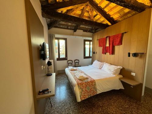 威尼斯TRA SAN MARCO E RIALTO的一间卧室设有一张带木制天花板的大床