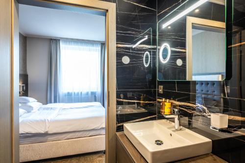 科马尔诺HOTEL EUROPA的一间带水槽、床和镜子的浴室