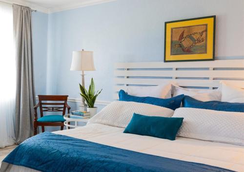 克里斯琴斯特德Arawak Bay: Inn at Salt River的蓝色和白色的卧室,配有床和椅子