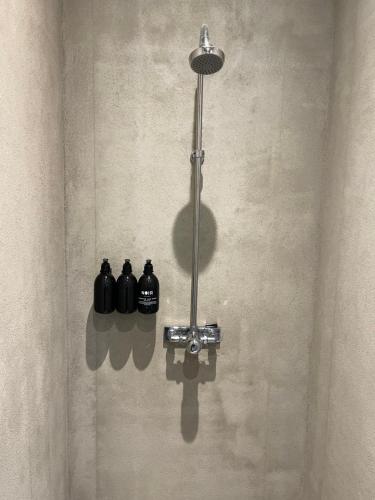 斯德哥尔摩Chambre hotell的墙上有三个黑色瓶子的淋浴