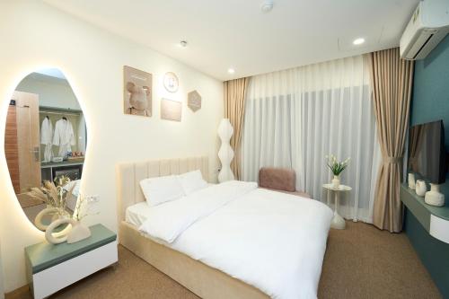 河内EDEN RESIDENCE的卧室配有白色的床和电视。