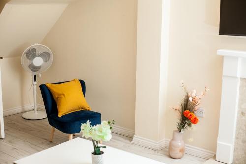纽尼顿Avril Warwickshire Home Stay的客厅配有蓝色椅子和黄色枕头